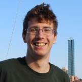 A person wearing glasses and smiling

Description automatically generated